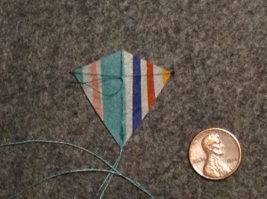 1.5 inch Sotich Eddy kite, striped cocktail napkin.